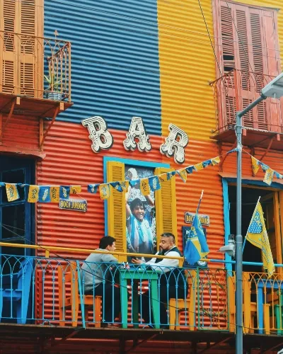 Two men sitting outside a colourful bar on an Argentina adventure