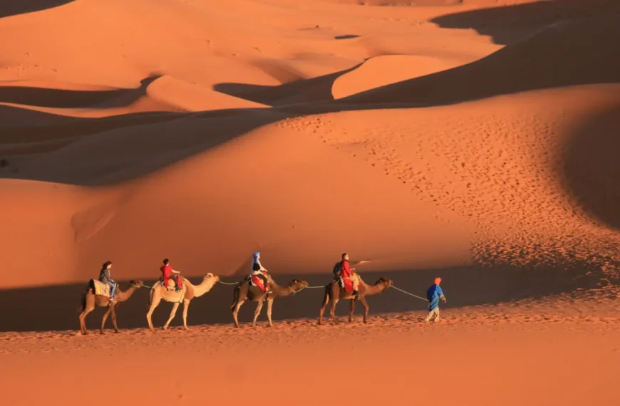 People riding camels across the Sahara Desert, which is one of the best places to visit in Morocco